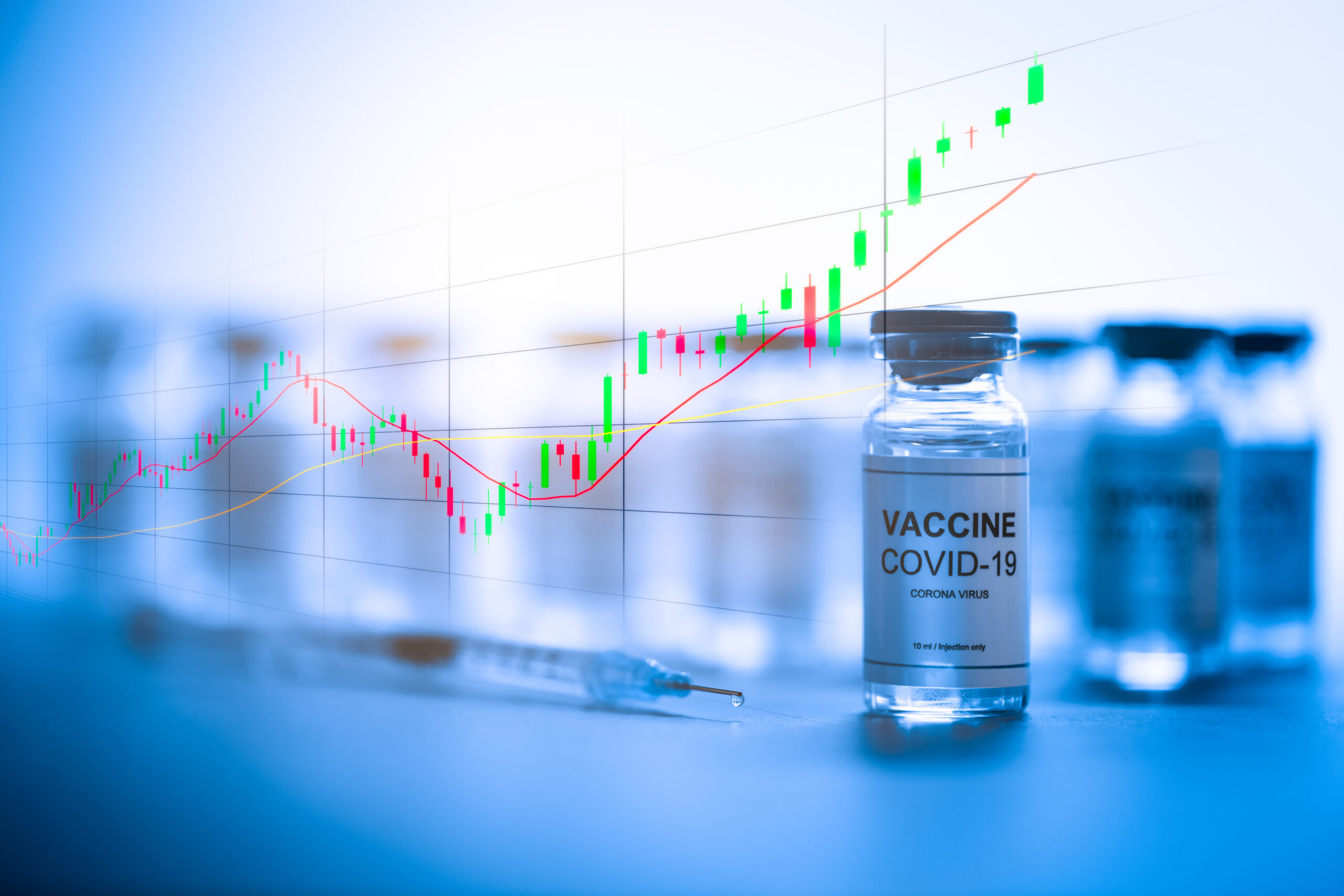 Upwards bullish stock market candlestick pattern over vials of new coronavirus Covid-19 vaccines on laboratory table