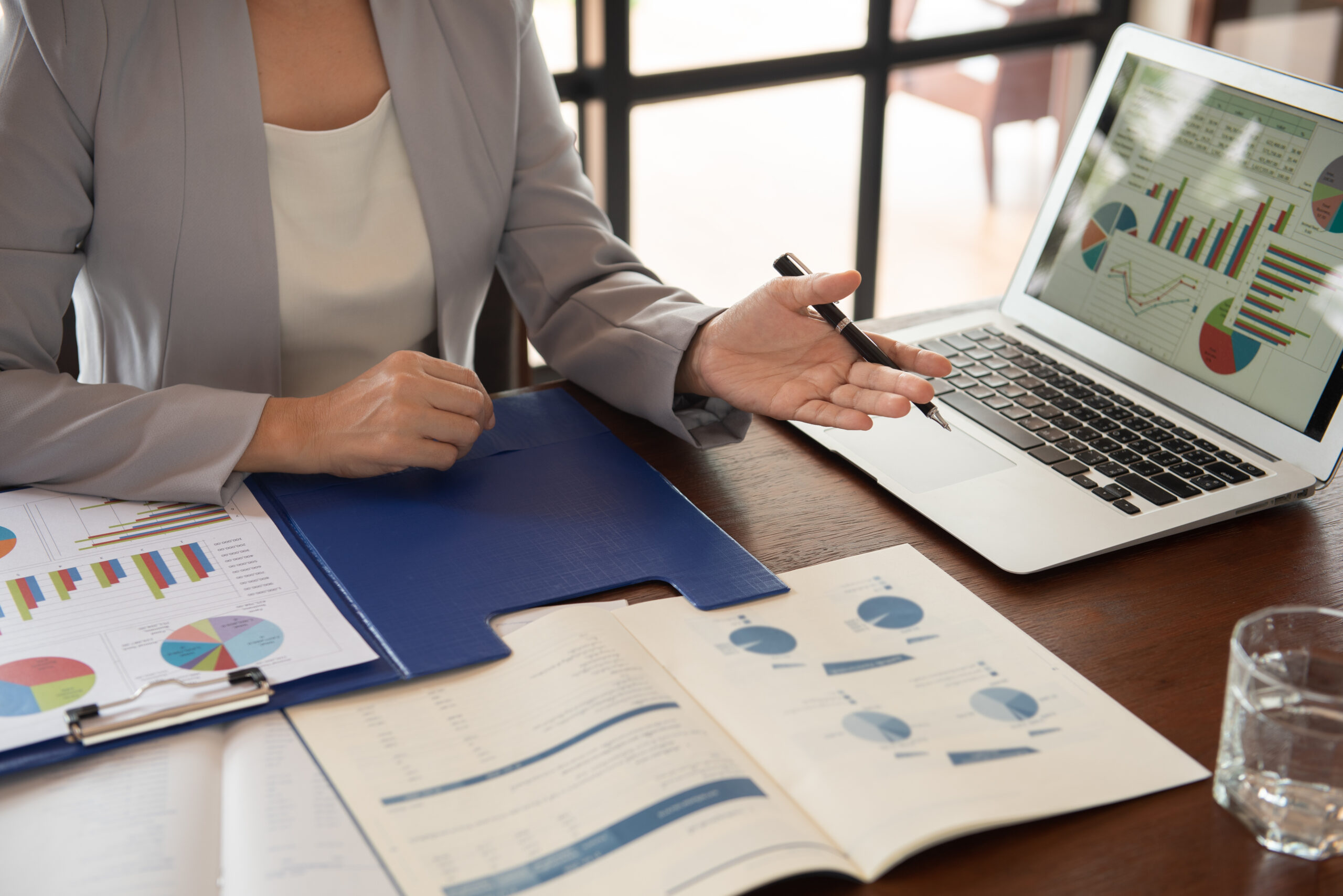 Business women reviewing data in financial statement with coworker analyzing market data research for new business startup.