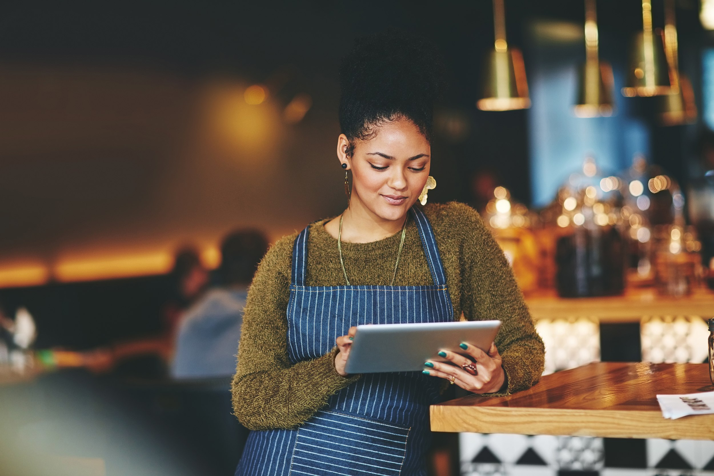 Shot of a young woman using a digital tablet while working at a coffee shop